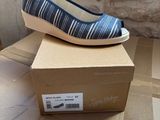 blue and white striped shoes on a cardboard box on a table
