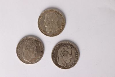 three coins are shown on a white surface with a white background