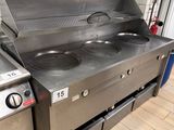 two stainless steel stoves in a kitchen with a tiled wall