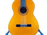 a guitar that is sitting on a stand on a white surface