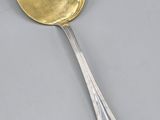 une cuillère en argent avec un couvercle en or et un manche de cuillère