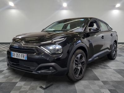 la voiture noire est garée sur un sol en damier dans le garage