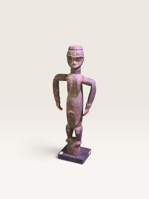 une statue représentant un homme debout sur un socle violet
