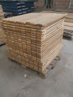 plusieurs piles de planches de bois empilées les unes sur les autres dans un entrepôt