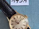 une photo d'une montre-bracelet en or montée sur un bracelet en cuir noir