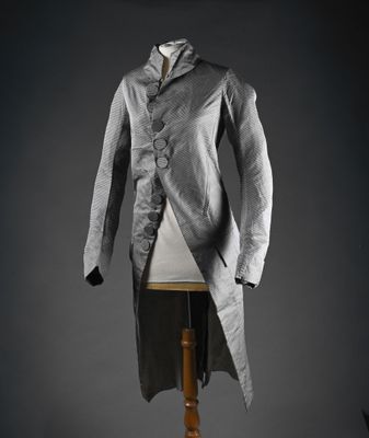 une veste grise posée sur un pied de mannequin