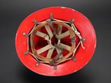 a red helmet with a wooden wheel on it