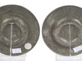 pair of silver plates on stands with tags on them