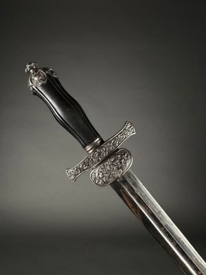 a close up of a sword with a silver handle on a black background