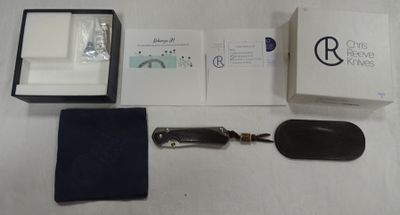 une boîte contenant une montre, un porte-clés et d'autres objets, posée sur une table