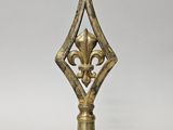 un objet métallique de couleur dorée orné d'un motif décoratif
