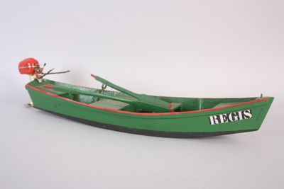un petit bateau vert avec un homme à bord, sur une surface blanche