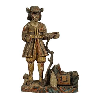 statue en bois représentant un homme avec un chien et des valises, sur fond blanc