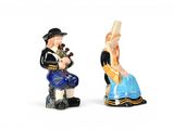 two figurines of a man and a woman sitting on a bench