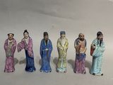 five figurines of people standing in a row