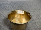 a small brass bowl with a label on it