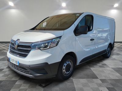 Une camionnette blanche est garée dans une pièce au sol carrelé en damier.