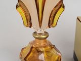 a small glass perfume bottle sitting next to a small box