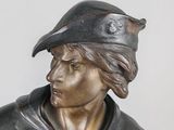 bronze statue of a man with a hat on his head