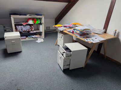 two desks in the corner of a room with a television