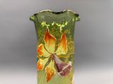 un vase vert orné d'une fleur jaune et rouge