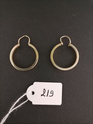 two gold hoop earrings and a price tag on a black background
