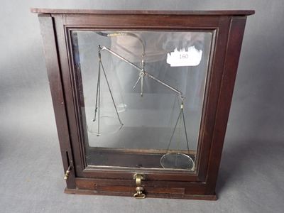 une vitrine en verre sur laquelle est posée une balance, posée sur une table