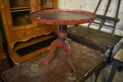 a red table with a wooden top sitting on a wooden table