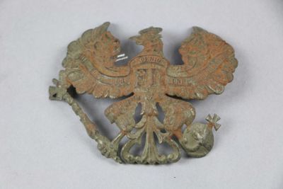 an old bronze brooch with a bird on it