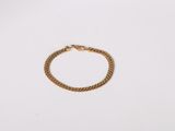 a close up of a gold chain bracelet on a white surface