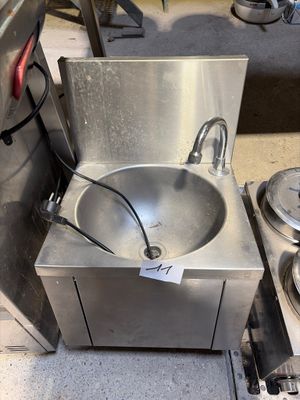 un évier en acier inoxydable placé à côté d'une cuisinière en acier inoxydable