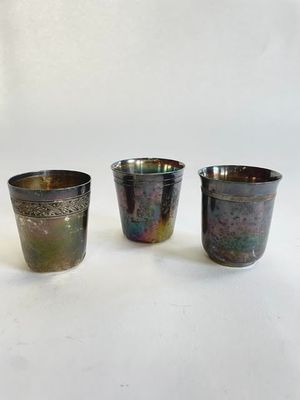 trois tasses de couleurs différentes posées les unes à côté des autres sur une surface blanche