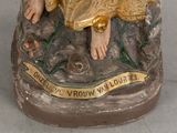 a statue of a woman sitting on top of a rock
