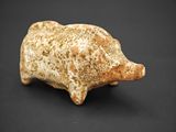 une vieille figurine en pierre représentant un cochon sur fond noir