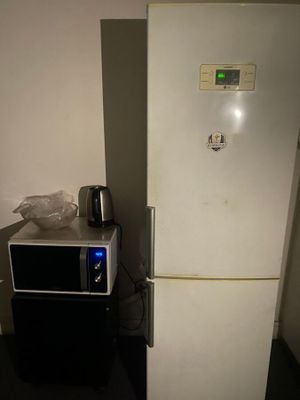 un réfrigérateur blanc et un micro-ondes dans une petite pièce