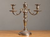 un candélabre en argent avec trois bougies, posé sur une table