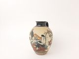 a vase with a painting on it sitting on a table