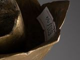 a bronze sculpture of a hat on a wooden stand
