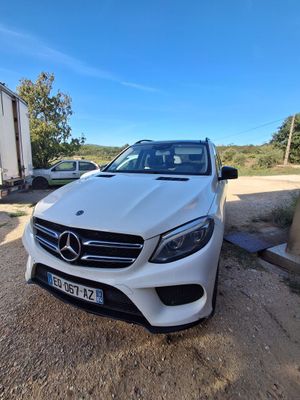 a white mercedes gle parked in front of a trailer
