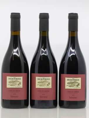 trois bouteilles de vin posées sur une table l'une à côté de l'autre