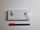 a red pen sitting next to a white box on a table
