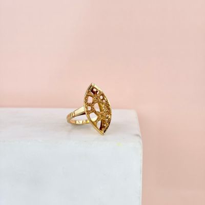 un gros plan d'une bague en or posée sur un bloc blanc