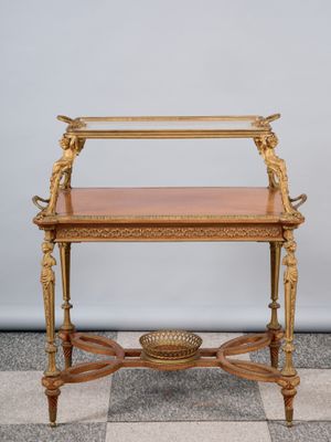 une table ancienne en bois avec un plateau en verre, posée sur un sol en damier