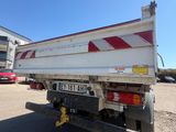 a white truck with red stripes parked in a parking lot