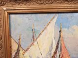 a painting of a sailboat on display in a gold frame