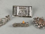 three silver brooches and a silver broochle on a table
