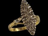 un gros plan d'une bague en or sertie de diamants sur fond noir
