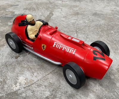 une petite voiture rouge avec un ours en peluche à l'intérieur