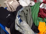 a pile of clothes sitting on the floor next to a chair