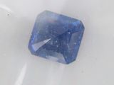 a blue diamond that is sitting on a white surface
